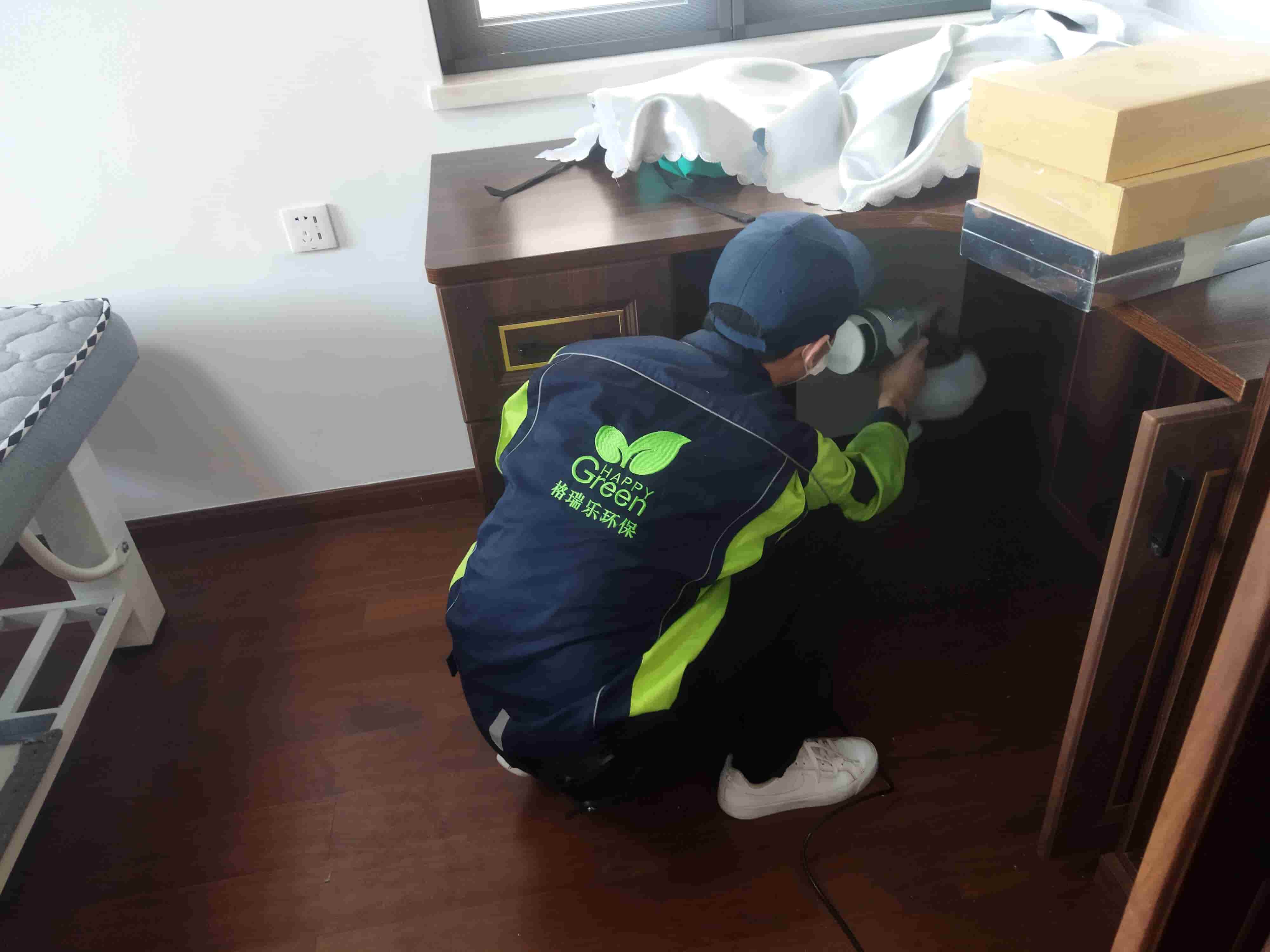 画面呈现新房卫生间，在瓷砖铺贴完成后，工人用喷枪对瓷砖与瓷砖之间的缝隙进行除甲醛密封胶填充。