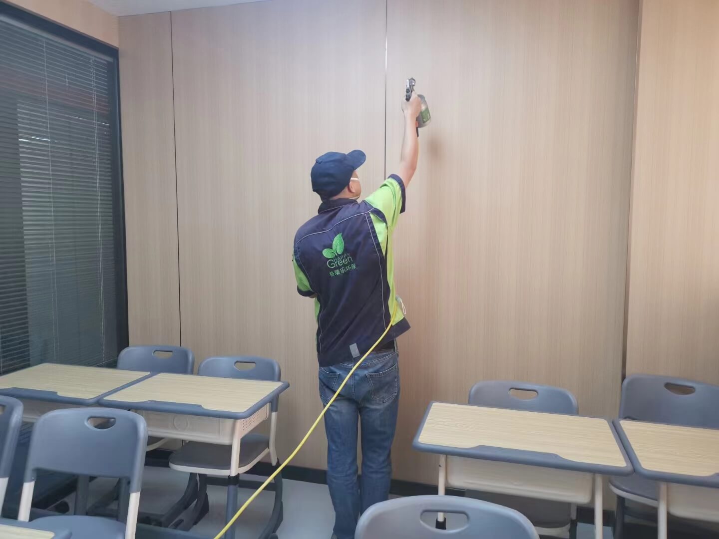 客厅电视柜安装现场，工人用湿布蘸取格瑞乐除甲醛清洁液，仔细擦拭抽屉轨道，去除潜在甲醛。