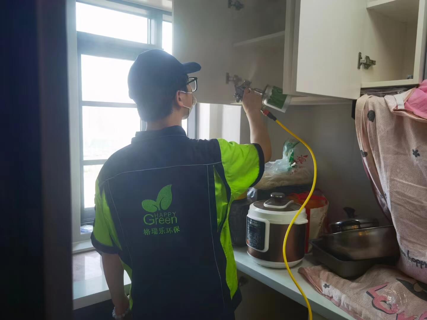 新房走廊的鞋柜旁，工人在鞋柜的层板边缘粘贴格瑞乐除甲醛纳米矿晶吸附条，增强除醛效果。